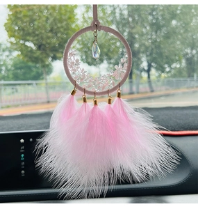 Dettaglio dell'acchiappasogni rosa per auto con piume e ciondolo in cristallo