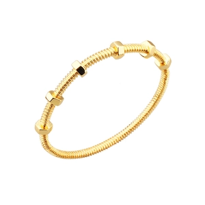 Industrial style gold-plated metal bracelet featuring threaded rod and hexagonal nuts