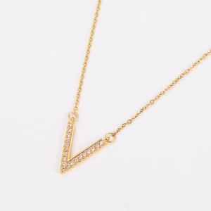 Detailed view of gold V-shaped pendant necklace with sparkling pave cubic zirconia