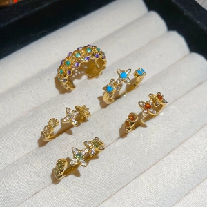 Detailed macro view of 18k gold plated star rings and ear cuff with colorful zircon inlay
