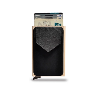 Detail of automatic champagne gold metal wallet with black Saffiano leather finish