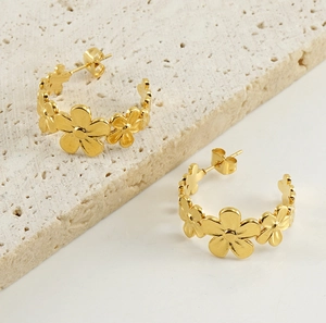 Detailed macro view of 18k gold plated stainless steel daisy floral hoop earrings