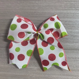 Détail d'un nœud de Noël à pois rouges et verts avec une bande centrale dorée