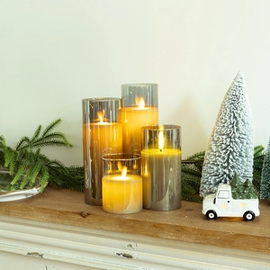 Set of 4 LED flameless candles in glass shells on a mantel for holiday decoration