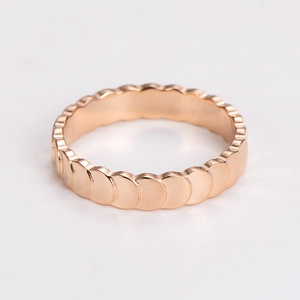 Detail of rose gold mermaid scale ring with overlapping circular metal discs design