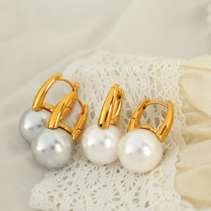 Elegant gold pearl hoop earrings set with grey and white pearls on silk background