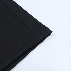 Gros plan d'une robe noire en résille montrant les coutures doubles et le tissu élastique
