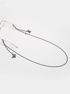 Détail de la chaîne de lunettes noire avec pendentif papillon évidé et boucles silicone