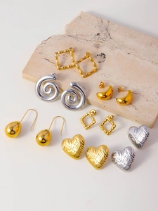 Detailed group view of gold and silver geometric earrings on minimalist stone display