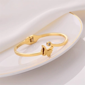 Elegant gold-tone open cuff bracelet featuring a frosted butterfly and zircon stone inlay