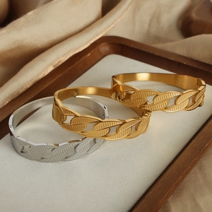 Minimalist chain style gold and silver plated titanium steel bangles on silk background