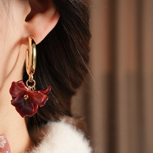 Detailed view of vintage resin flower earrings with gold hoops on a model's ear