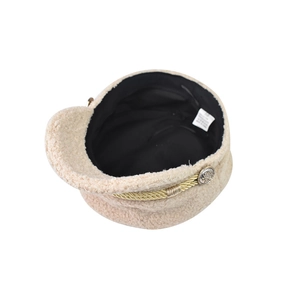 Detail view of beige newsboy hat with gold rope trim and embossed metal buttons