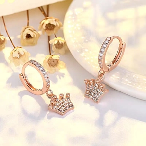 Detalle de pendientes de corona en oro rosa con pavé de circonitas blancas