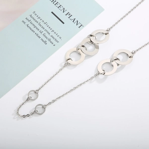 Close-up of silver titanium steel necklace featuring interlinked circular rings on white