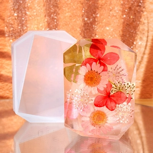Macro shot of geometric octagonal silicone mold with floral resin crystal on orange base
