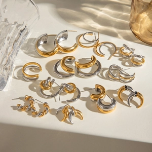 Collection of gold and silver C-shaped stainless steel earrings in various modern designs