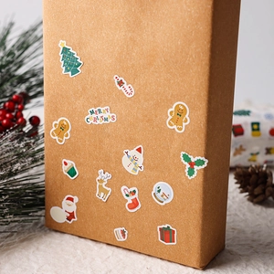 Close-up of Christmas stickers with Santa and reindeer on a brown kraft gift box