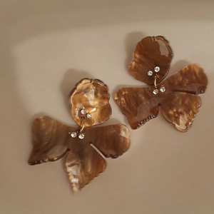 Detailed macro view of resin flower earring with amber texture and small crystal accents