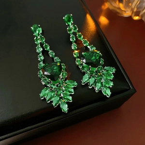 Macro shot of silver zircon heart and leaf drop earrings in a luxury display box