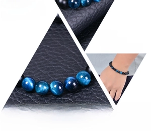 Détail du bracelet en perles d'oeil de tigre bleu et pierres noires sur du cuir
