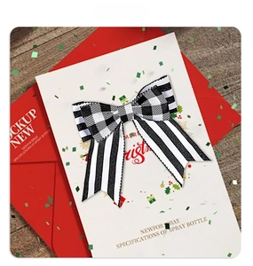Detail of checkered and striped Christmas bow on holiday card with wooden background