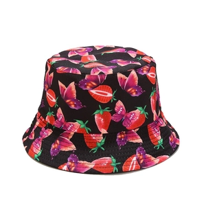 Reversible bucket hat with strawberry and butterfly patterns on a black cotton base