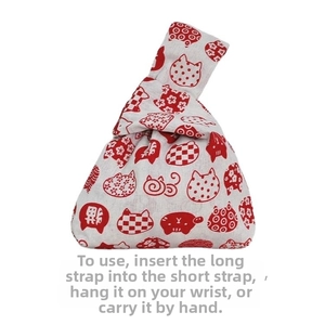 Japanese knot bag featuring red cat prints on cotton-linen fabric with wrist loop detail