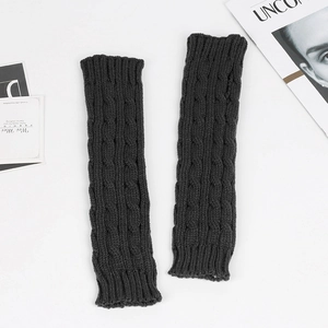 Detailed view of black cable knit long fingerless gloves with elastic ribbed cuffs on a white background