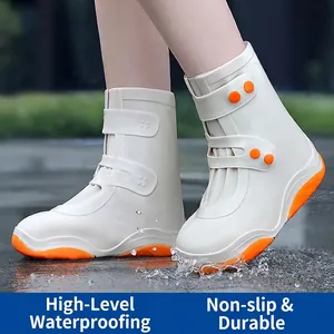 White high-top waterproof rain shoe covers with orange soles and secure double buckle straps