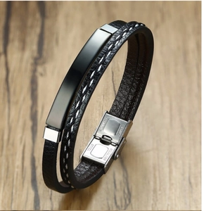 Men's double-layered black leather bracelet with stainless steel clasp on wood background