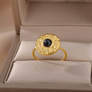 Detail of vintage gold sun ring with black stone and hammered texture in a jewelry box