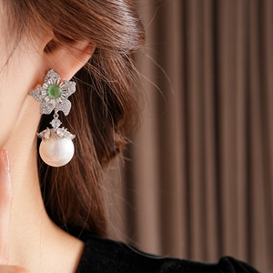 Boucles d'oreilles vintage fleurs avec pierres vertes, zircons et perles sur le mannequin