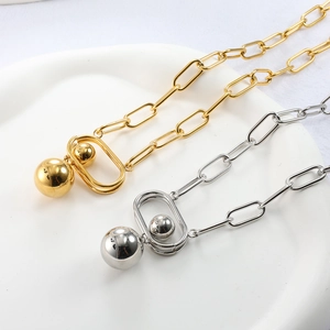 Detail of gold and silver paperclip chain necklaces with geometric ball pendants