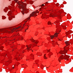 Close-up of sparkling red heart-shaped glitter confetti for Valentine's Day party decor
