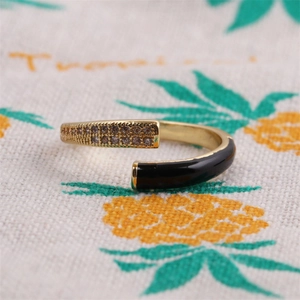 Detail of adjustable gold ring with sparkling rhinestones and black enamel finish
