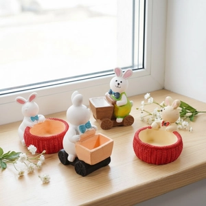 Detailed view of four miniature bunny figurines with carts and baskets for home decor