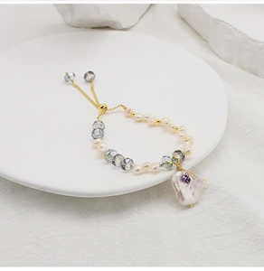 Close-up of baroque pearl and lavender crystal bead bracelet with golden chain detail