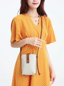Minimalist beige and brown genuine leather crossbody phone bag shown on a female model