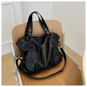 Detail of black large capacity canvas tote bag with metal rivets and adjustable strap