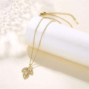 Collier feuille élégant en acier inoxydable doré avec zircons sur un support blanc