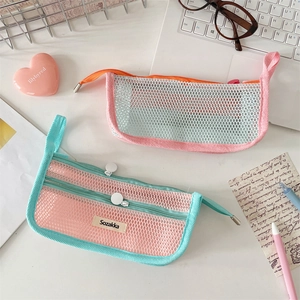 Detailed view of colorful mesh pencil cases with zippers on a clean study desk setup