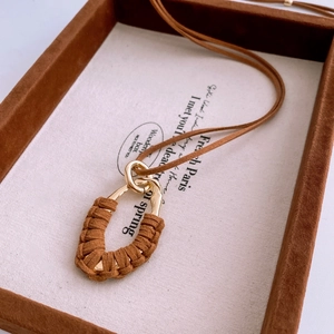 Gros plan du pendentif goutte d'eau vintage avec texture en suédine marron
