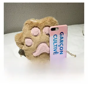 Detailed size comparison of the plush cat paw crossbody bag shown next to a smartphone