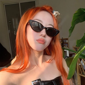 Front view of a model wearing retro black cat-eye sunglasses with dark tinted lenses