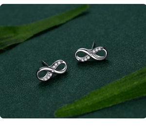 Macro detail of S925 sterling silver infinity stud earrings with sparkling zircon inlay