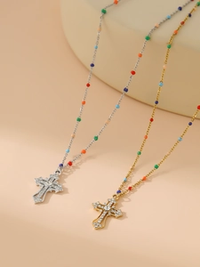 Detail of colorful beaded chain with diamond-encrusted cross pendant in gold and silver