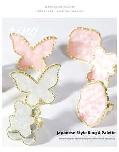 Macro detail of resin nail art palette rings with faux agate texture and golden edges