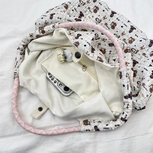 Internal detail of canvas tote bag featuring metal snap closure and zippered inner pocket