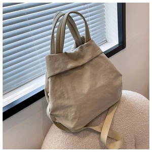 Detail view of lightweight beige nylon handbag with natural crinkle texture and dual straps